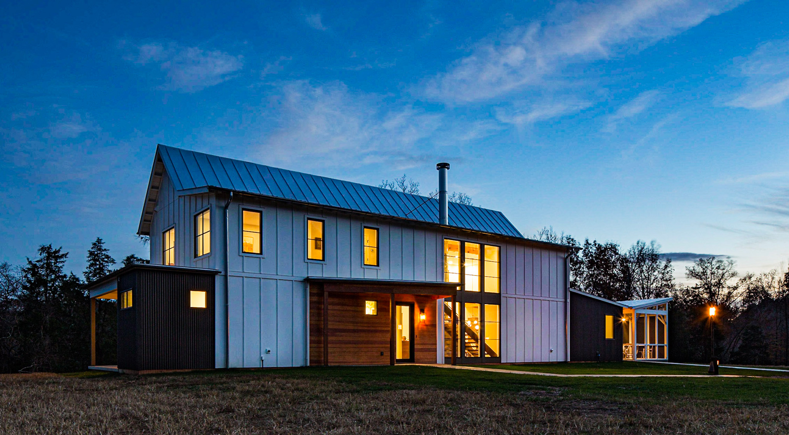 A modern farmhouse photographed from the exterior at dusk